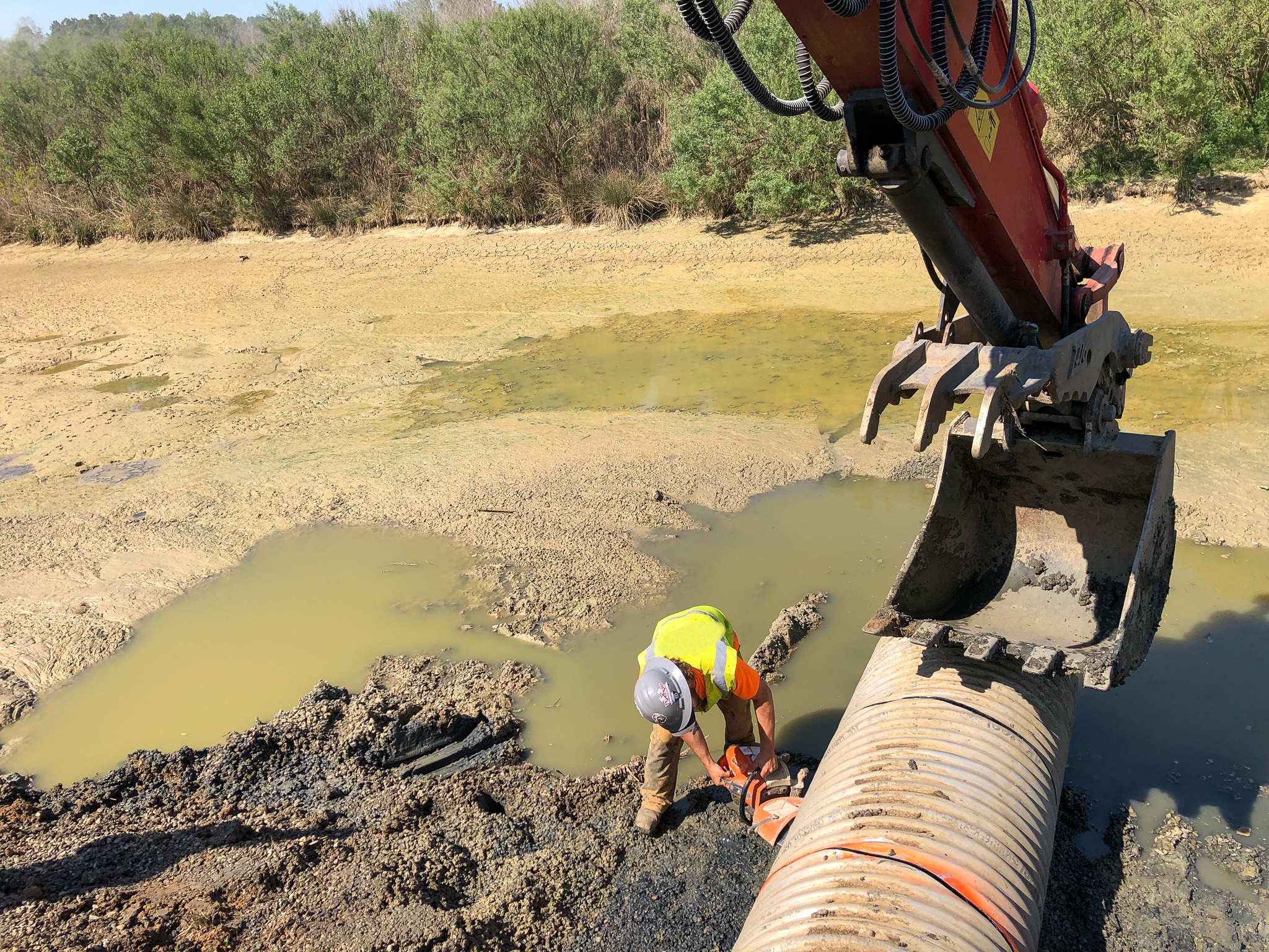 Stormwater pipe repair on drained retention pond — LMS pond and stormwater management corrective repair services Houston TX